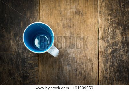 White Cup Inside Blue Colored On Wooden Background