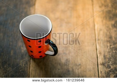Spotted cup white inside on wooden background