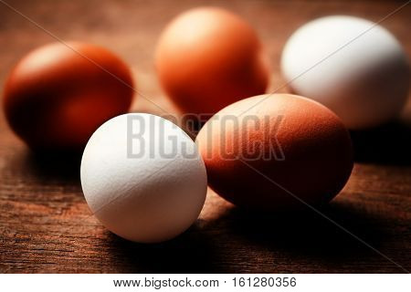 Farm eggs on a wooden rustic table close up. Fresh brown and white eggs macro with copy space