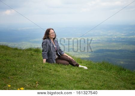 Middle Aged Woman Sitting On The Slope Of Volcano