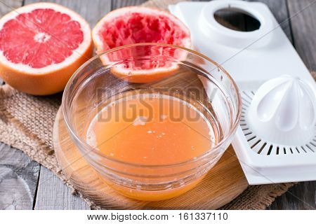 squeezing juice from an orange on a manual squeezer