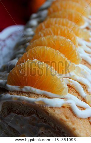 Biscuit and Cake with Mandarin and Whipped Cream. А kandle and mandarins are on the table.