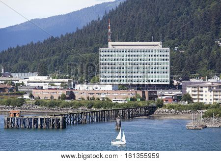 The small boat passing by the government building in Juneau the capital of Alaska.
