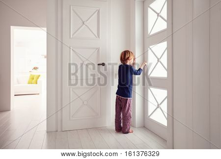 Young Boy Opens The Door At Home