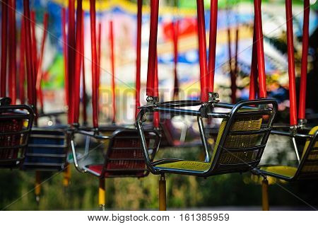 the empty seats of the children's carousel in the Park