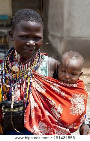 BISIL, KENYA-DECEMBER 7, 2010: Portrait of unidentified Maasai woman and child in a rural village in Kenya