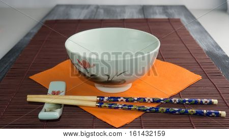 Bone Chinese chopsticks with a bowl on a brown background