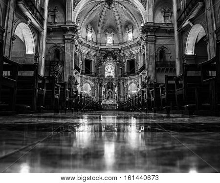 ELCHE SPAIN - JULY 6 2015: Inside the Basilica Menor de Santa Maria. Main altar with reflection in the floor. Black and white interior in Elche Spain