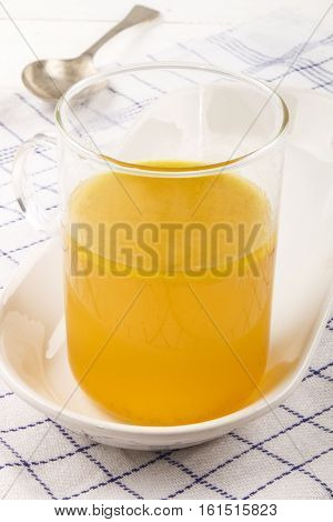 homemade chicken broth in a glass during the winter time well suited for cold