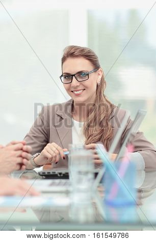 Happy business people looking at camera in office and  using com