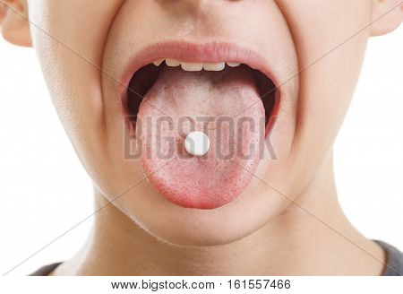 Pill on the tongue of the patient closeup. Treatment of influenza and common cold isolated on white