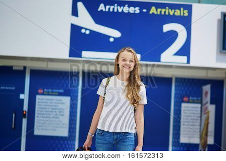 Beautiful Young Tourist Girl With Backpack And Carry On Luggage In International Airport
