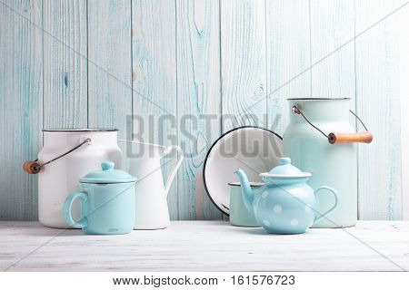 Enamelware on the kitchen table over blue wooden wall