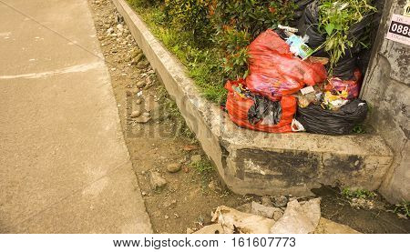plastic trash bag in sidewalk using red bags photo taken in depok jakarta indonesia java