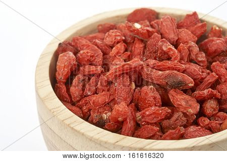 goji berry in wooden cup on white background.