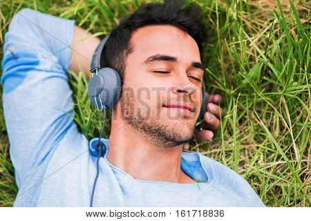Upper view.Close-up portrait of young man enjoying and dreaming with headphones listen the music