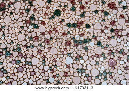 A stone walkway with colourful patterns of white red and green