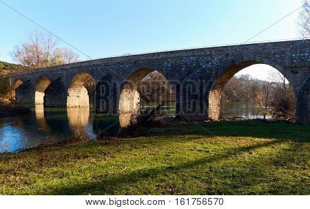 Ancient bridge across Ceze river in La Roque-sur-Ceze. Picturesque village on a southern France. Languedoc-Roussillon