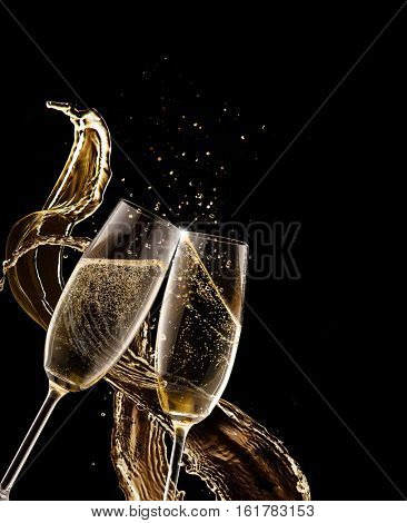 Two glasses of champagne with splash over black background. Celebration concept, free space for text