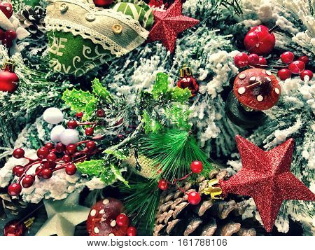 Close up of Christmas tree decorations like stars, tree leaves, oranges and bables. Ideal to use for seasonal backgrounds