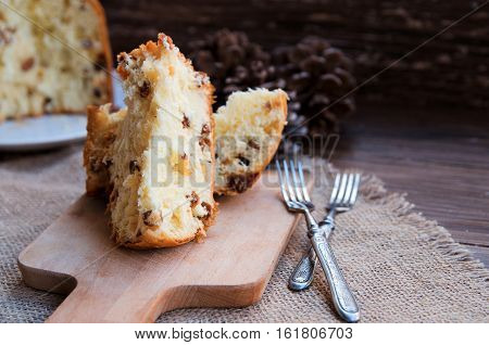 Panettone Traditional Italian Christmas cake on rustic background with vintage fork. Copy space.