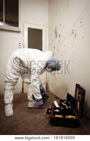 Criminologist technician documenting evidences of blood stains