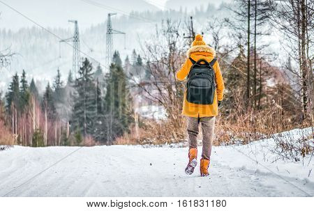 Traveler Goes On Snow Covered Road In Winter Forest