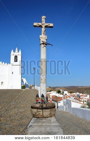 MERTOLA, PORTUGAL: The Matriz Church  (former Mosque of Mertola) with a religious cross in the foreground