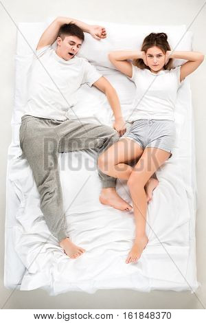 The young lovely couple lying in a white bed, love lconcept, top view