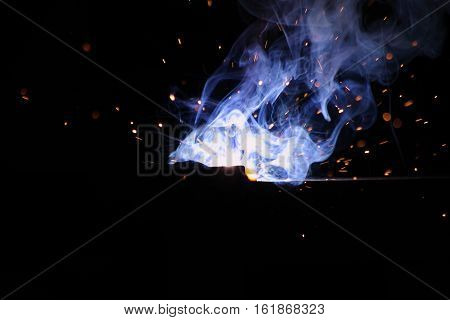 Worker Welding Metal with sparks and smoke