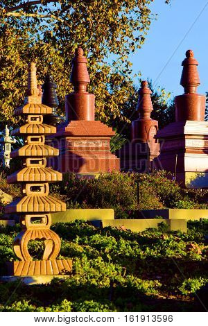 Gravesites with tall headstones taken in a Buddhist Cemetery