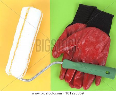 Paint roller and red nitrile gloves on a colorful background