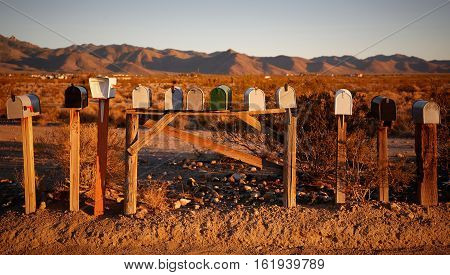 Several mailboxes in the desert during sunset