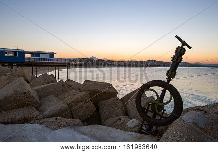 Italy Pescara old fishing equipments on the breackwater of the harbor at sunset