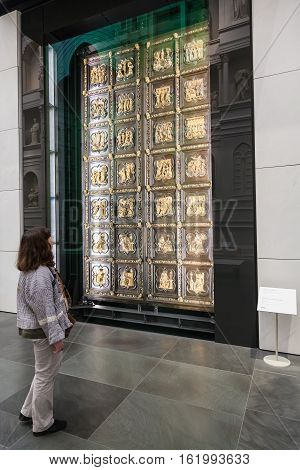 Tourist Near Original Doors Of Florence Cathedral