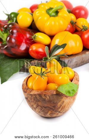 Assorted tomatoes and vegetables isolated on white background. Photo for your design
