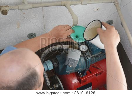Kyiv, Ukraine - October 15, 2018: Contractor Installing Water Pump Station Adding Water In The Boreh