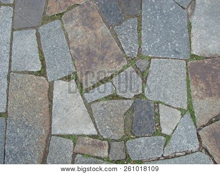 Texture, Background. The Pavement Of Granite Stone. Old Cobblestone Road Pavement Texture, Grass Bet
