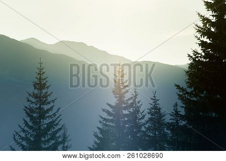 A Dreamy, Hazy Landscape Of A Mountains Close To Sunset. Sun Flase And Misty Look In Blue Tones. Mo