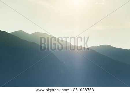A Dreamy, Hazy Landscape Of A Mountains Close To Sunset. Sun Flase And Misty Look In Blue Tones. Mo
