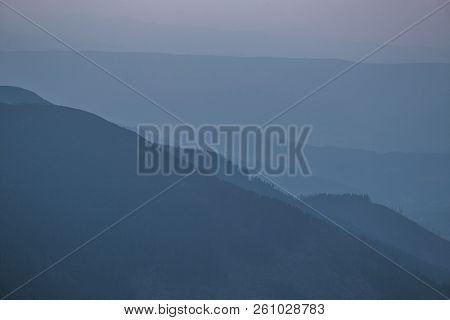 A Dreamy, Hazy Landscape Of A Mountains Close To Sunset. Sun Flase And Misty Look In Blue Tones. Mo