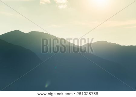 A Dreamy, Hazy Landscape Of A Mountains Close To Sunset. Sun Flase And Misty Look In Blue Tones. Mo