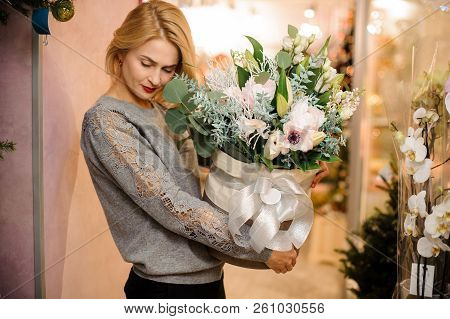 Young Beautiful Girl In Grey Shirt Holding In Her Hands A Huge White Box Of Tender White Flowers Dec