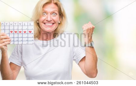 Middle age blonde woman holding menstruation calendar ver isolated background screaming proud and celebrating victory and success very excited, cheering emotion