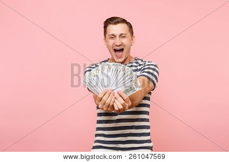 Portrait Of Happy Excited Young Man In Striped T-shirt Holding Bundle Lots Of Dollars, Cash Money, A
