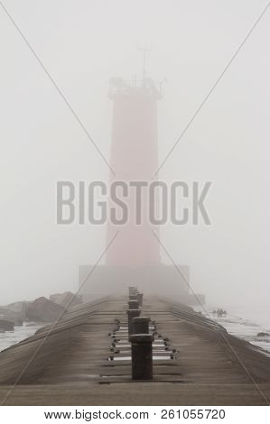 A Pier On Lake Michigan With A Lighthouse Obscured By Thick Fog.  Sheboygan, Wisconsin, Usa.