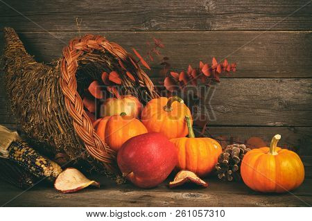 Thanksgiving Cornucopia Filled With Pumpkins And Apples Against A Rustic Wooden Background