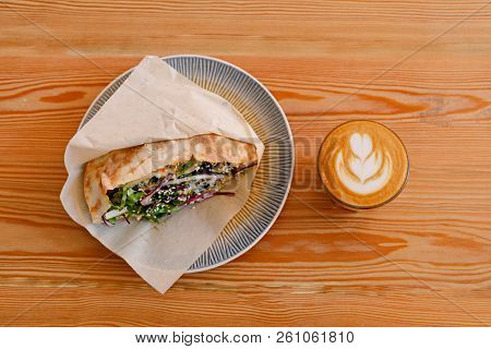 Shaverma Sandwich Chicken Roll In Pita With Fresh Vegetables And Flat-white On Wooden Table Top View