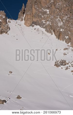 hiking touring ski tracks in snow climbing to mountain top at beautiful winter day with fresh snow