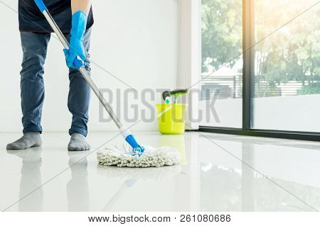 Young Housekeeper Cleaning Floor Mobbing Holding Mop And Plastic Bucket With Brushes, Gloves And Det